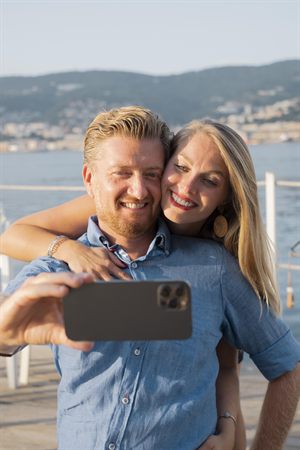 Couple smiling together in a selfie by the water
