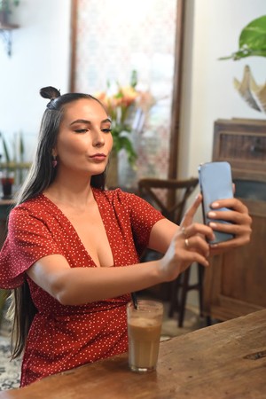 Woman taking a selfie at a coffee shop